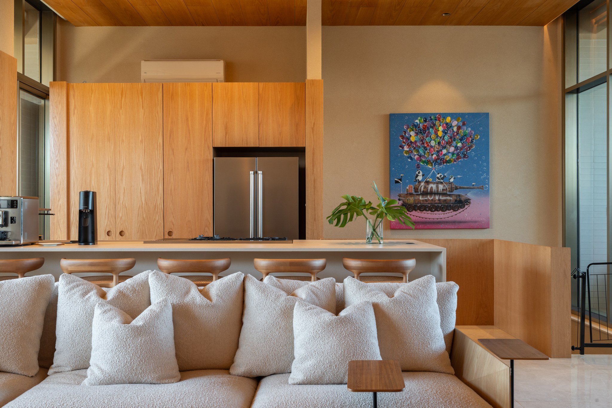 Detalhe da cozinha em madeira com geladeira embutida e quadro colorido ao fundo