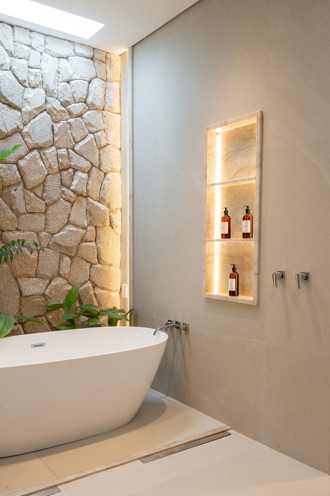 Detalhe do corredor em mármore com nicho iluminado refletido nos espelhos ao infinito