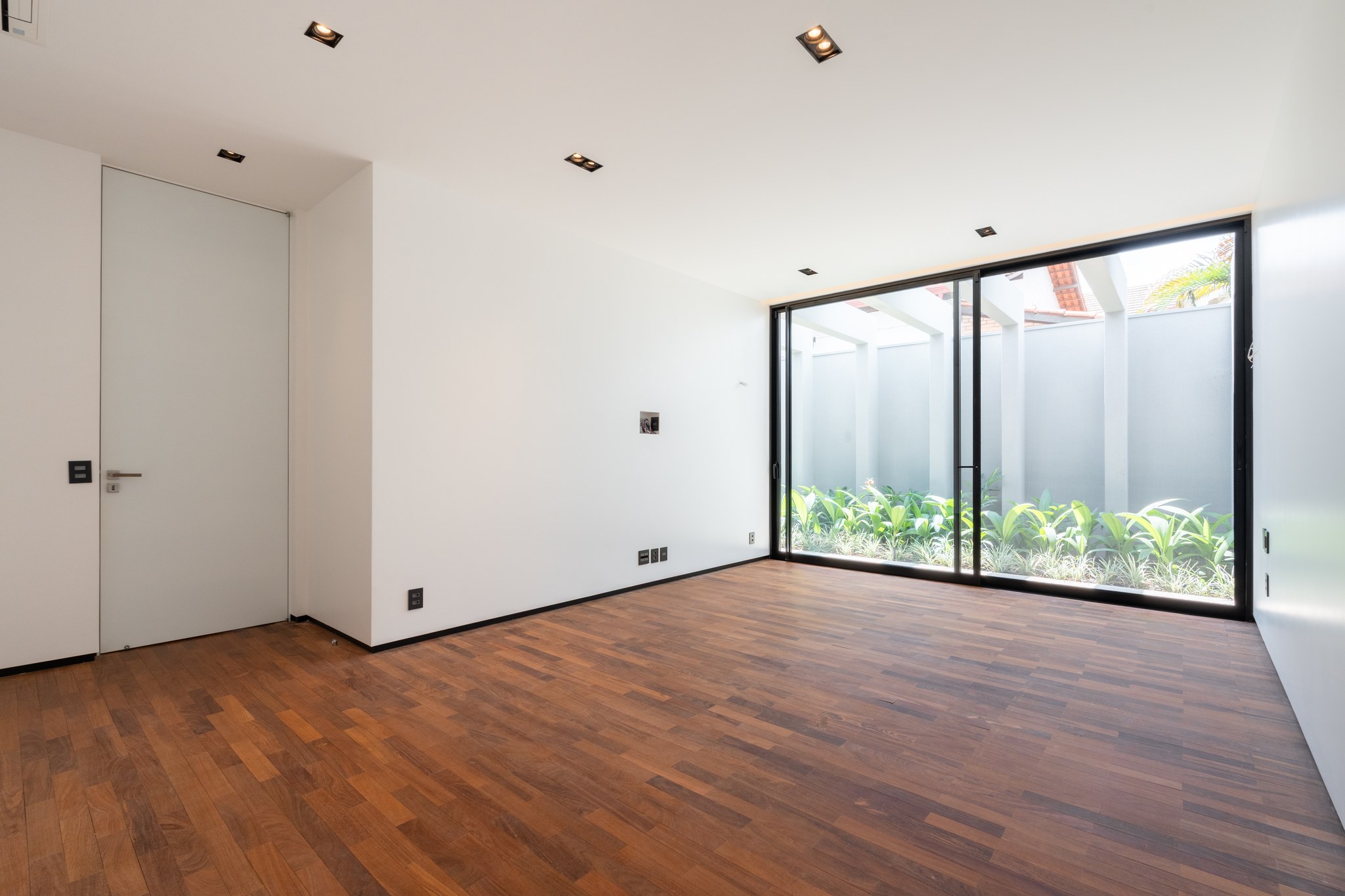 Closet em acabamento branco com ilha central, prateleiras e cabideiros ainda sem iluminação final acesa