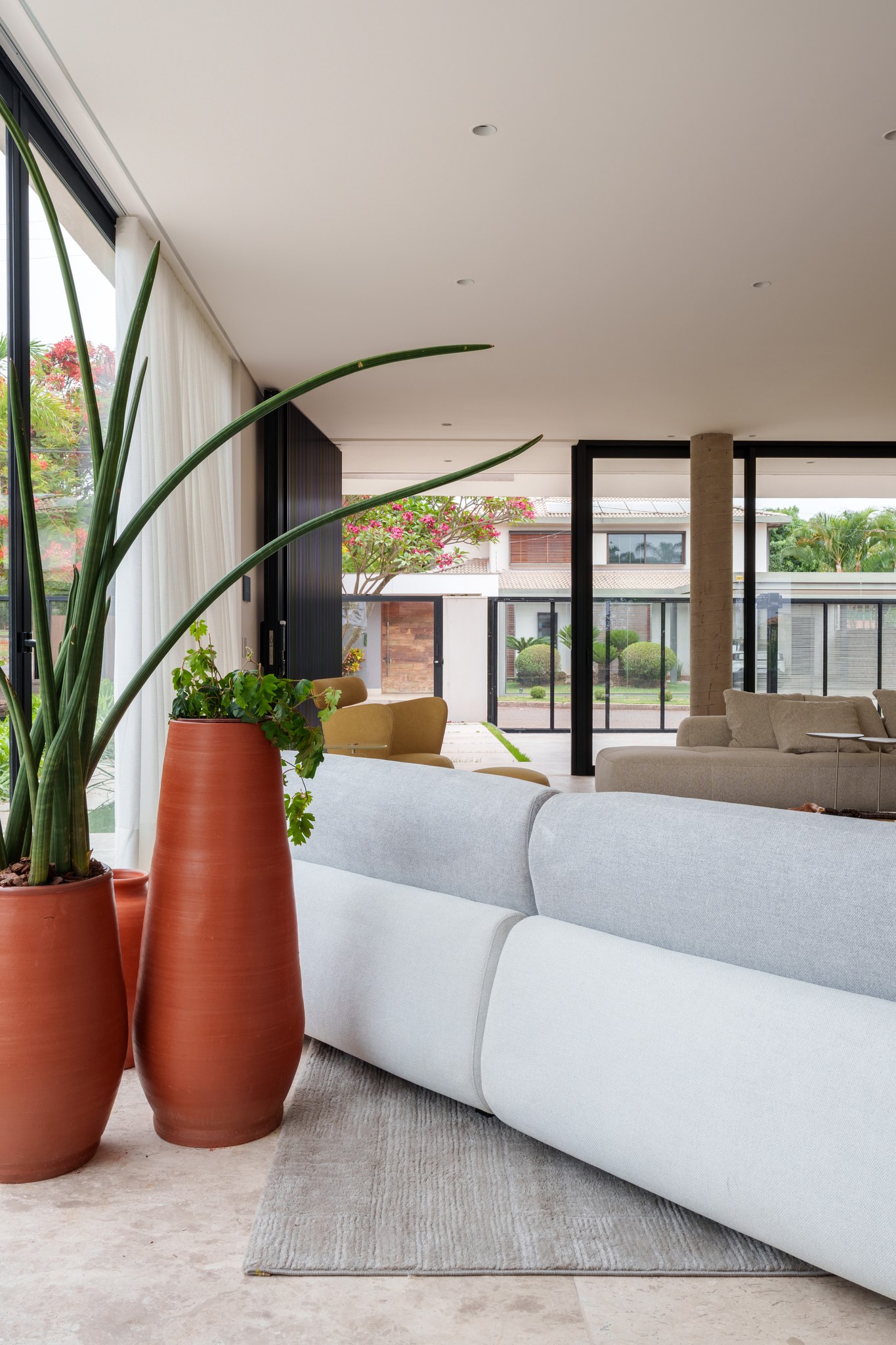 Vista aérea do terreno com piscina, pergolado e quadra, entre casas vizinhas e vegetação